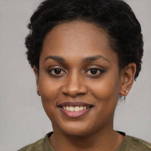 Joyful black young-adult female with short  black hair and brown eyes