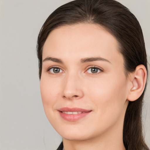 Joyful white young-adult female with long  brown hair and brown eyes