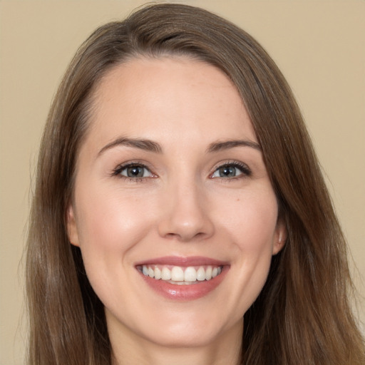 Joyful white young-adult female with long  brown hair and brown eyes