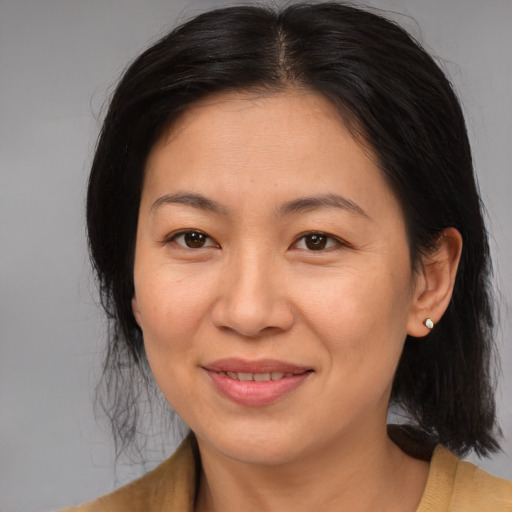 Joyful asian adult female with medium  brown hair and brown eyes
