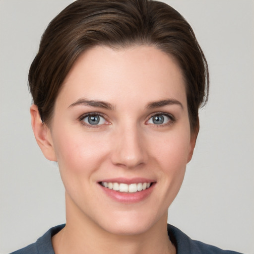 Joyful white young-adult female with short  brown hair and grey eyes