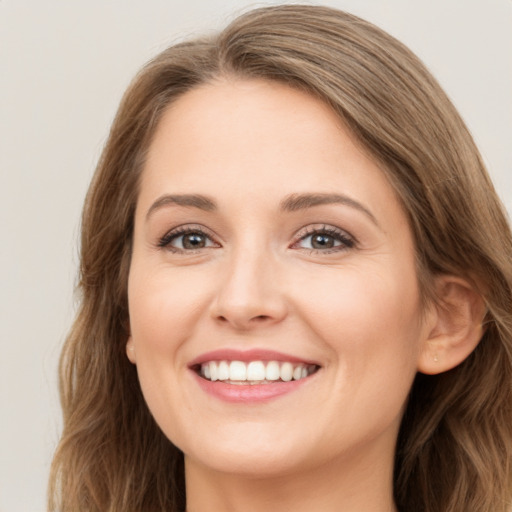 Joyful white young-adult female with long  brown hair and brown eyes