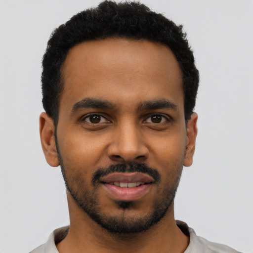 Joyful black young-adult male with short  black hair and brown eyes