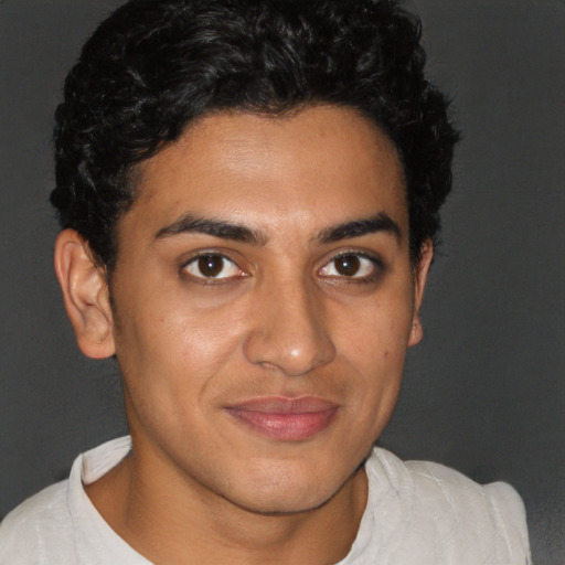 Joyful latino young-adult male with short  brown hair and brown eyes