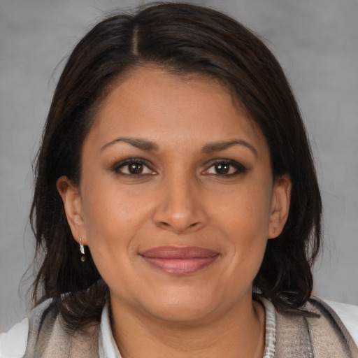 Joyful latino adult female with medium  brown hair and brown eyes