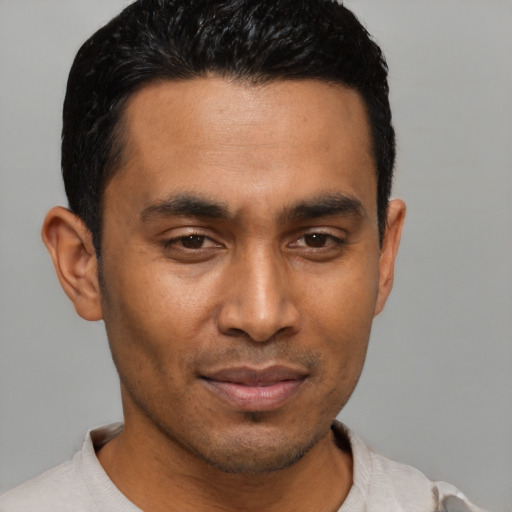 Joyful latino young-adult male with short  black hair and brown eyes