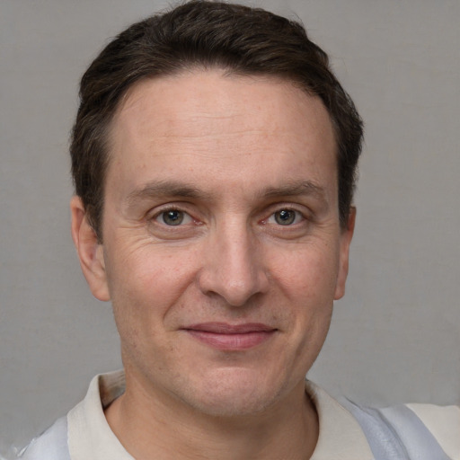 Joyful white adult male with short  brown hair and grey eyes