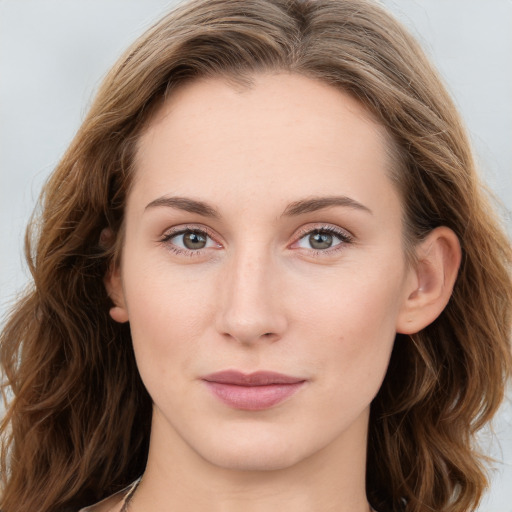 Joyful white young-adult female with long  brown hair and blue eyes