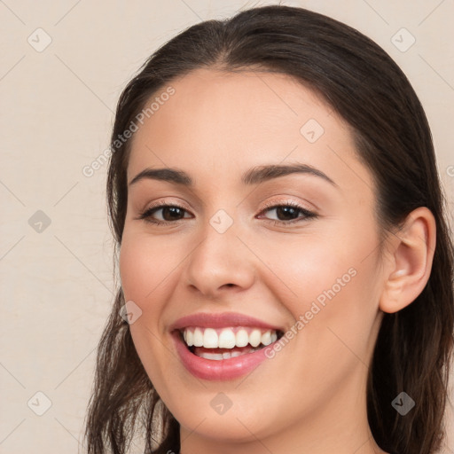 Joyful white young-adult female with long  brown hair and brown eyes