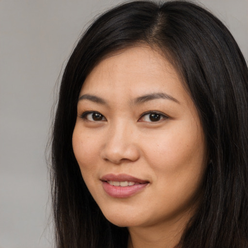 Joyful asian young-adult female with long  brown hair and brown eyes