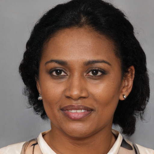Joyful latino adult female with medium  brown hair and brown eyes