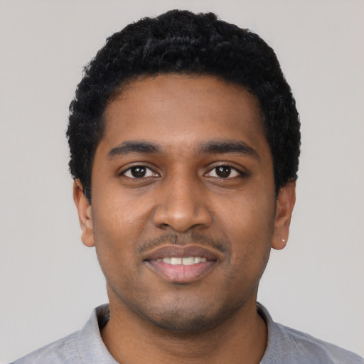 Joyful black young-adult male with short  black hair and brown eyes