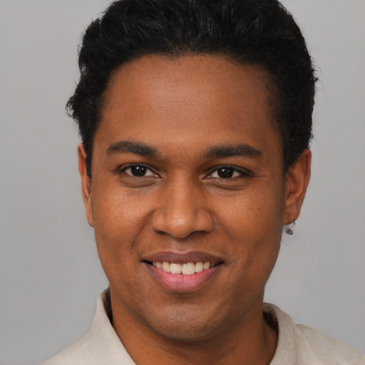 Joyful black young-adult male with short  black hair and brown eyes
