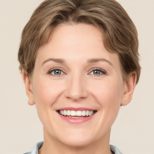 Joyful white young-adult female with short  brown hair and grey eyes