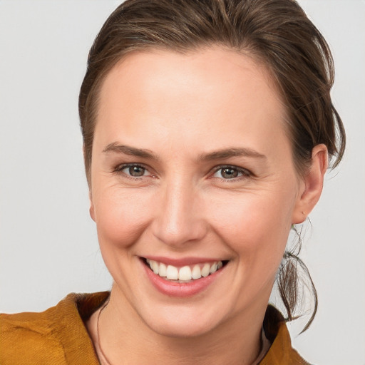 Joyful white young-adult female with medium  brown hair and grey eyes