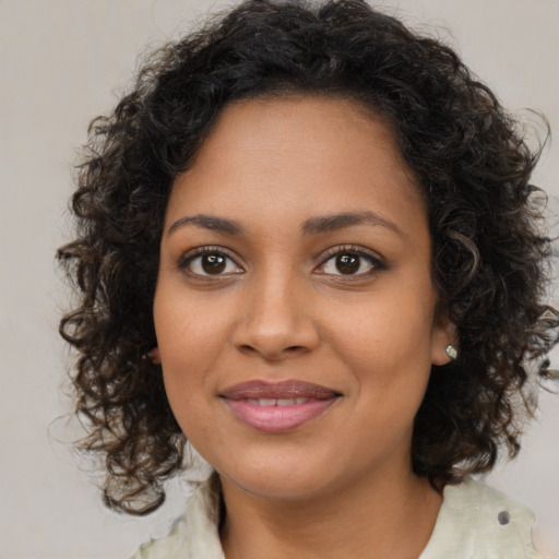 Joyful black young-adult female with medium  brown hair and brown eyes