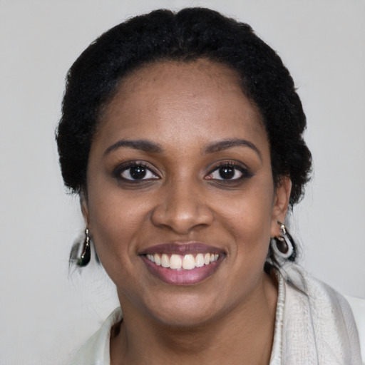Joyful black young-adult female with short  black hair and brown eyes