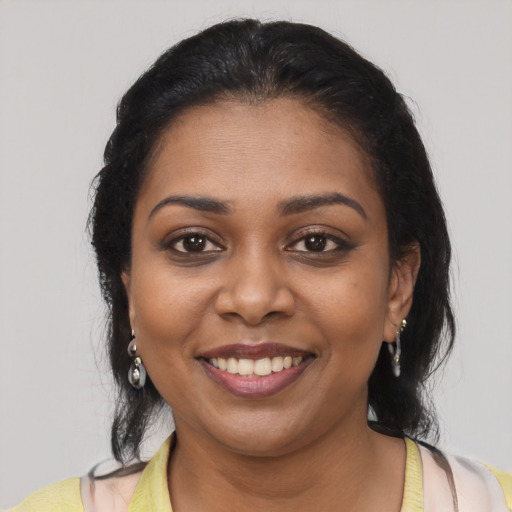 Joyful black young-adult female with medium  brown hair and brown eyes