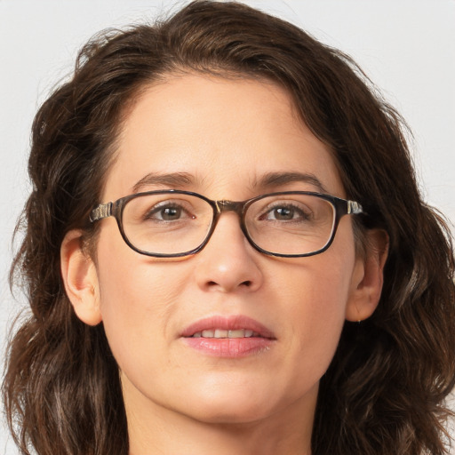 Joyful white adult female with long  brown hair and green eyes