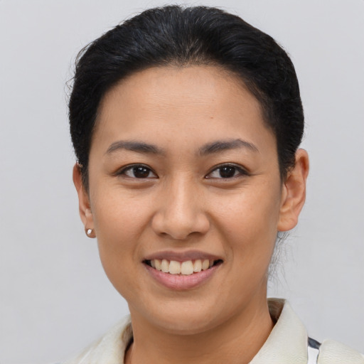 Joyful latino young-adult female with short  brown hair and brown eyes