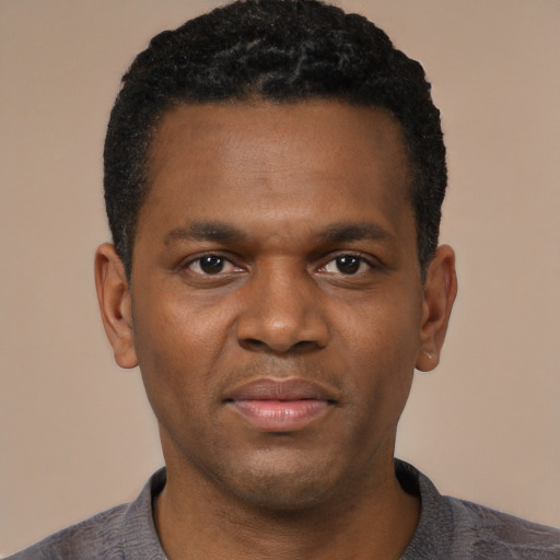 Joyful black young-adult male with short  black hair and brown eyes