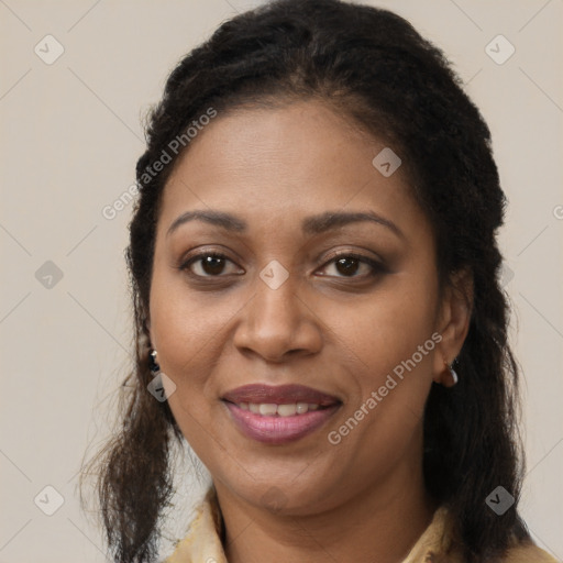 Joyful black young-adult female with long  brown hair and brown eyes