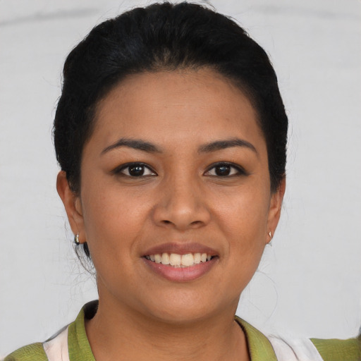 Joyful latino young-adult female with short  black hair and brown eyes