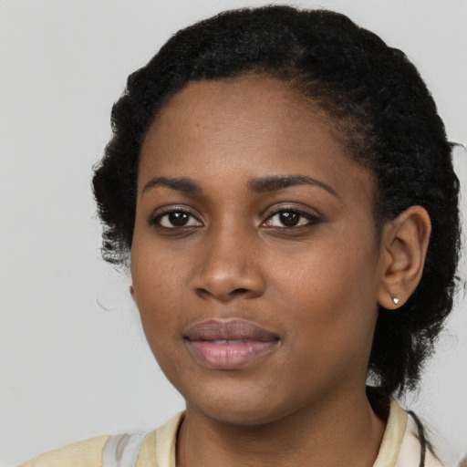 Joyful black young-adult female with long  black hair and brown eyes