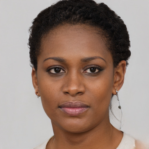Joyful black young-adult female with short  black hair and brown eyes