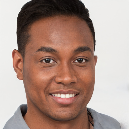 Joyful black young-adult male with short  brown hair and brown eyes