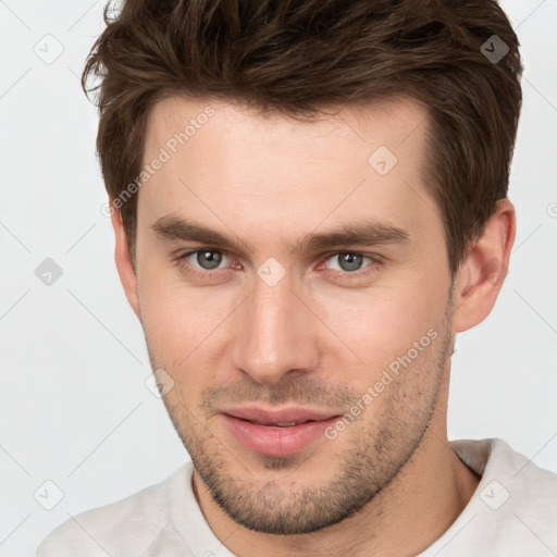 Joyful white young-adult male with short  brown hair and grey eyes