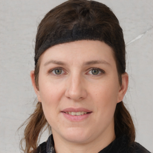 Joyful white young-adult female with medium  brown hair and grey eyes