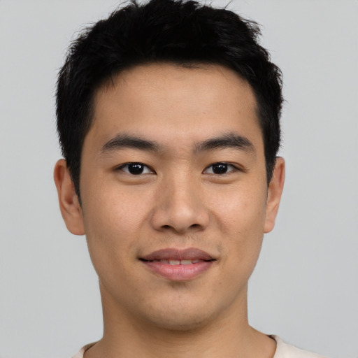 Joyful asian young-adult male with short  black hair and brown eyes