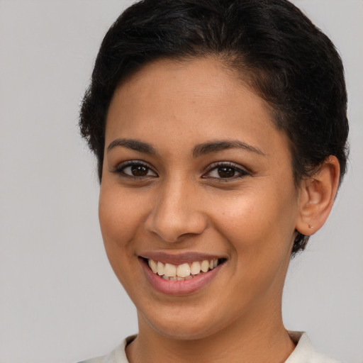 Joyful latino young-adult female with short  brown hair and brown eyes
