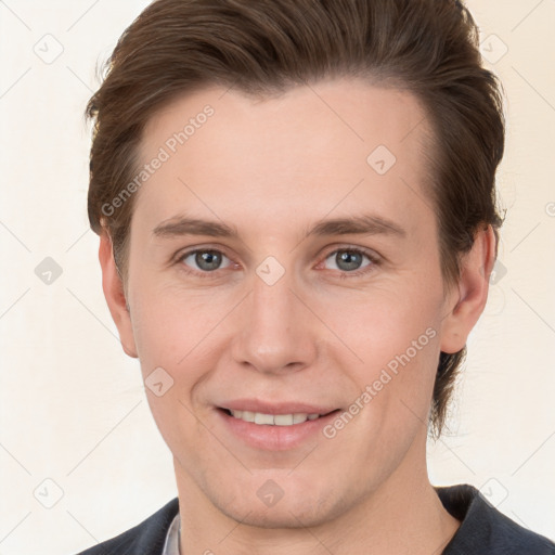 Joyful white young-adult male with short  brown hair and grey eyes