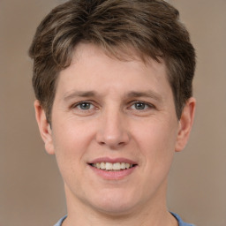 Joyful white young-adult male with short  brown hair and grey eyes