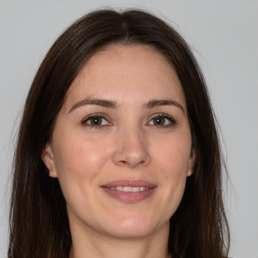 Joyful white young-adult female with long  brown hair and brown eyes