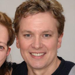 Joyful white adult female with medium  brown hair and blue eyes