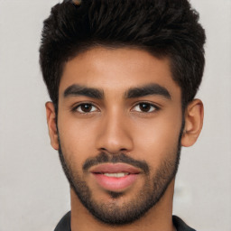 Joyful latino young-adult male with short  black hair and brown eyes