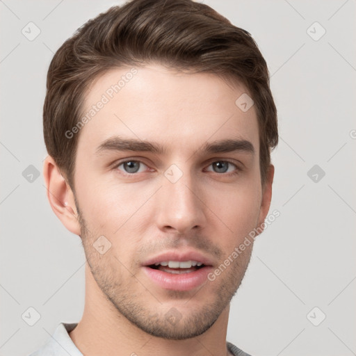 Joyful white young-adult male with short  brown hair and grey eyes