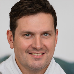 Joyful white adult male with short  brown hair and brown eyes