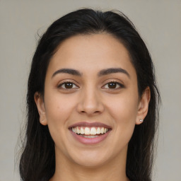 Joyful latino young-adult female with long  brown hair and brown eyes