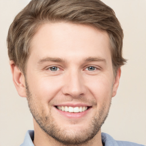 Joyful white young-adult male with short  brown hair and grey eyes