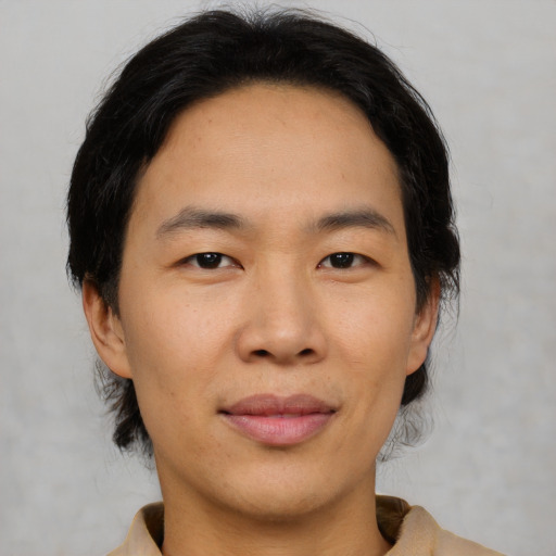 Joyful asian young-adult male with medium  brown hair and brown eyes