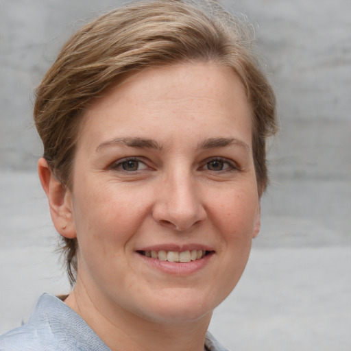 Joyful white young-adult female with short  brown hair and grey eyes