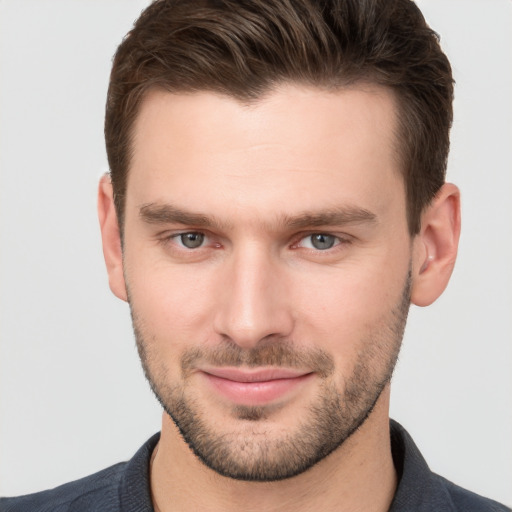 Joyful white young-adult male with short  brown hair and grey eyes