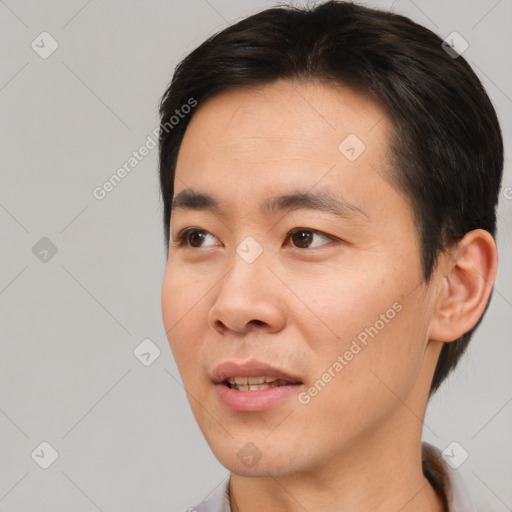 Joyful asian young-adult male with short  brown hair and brown eyes