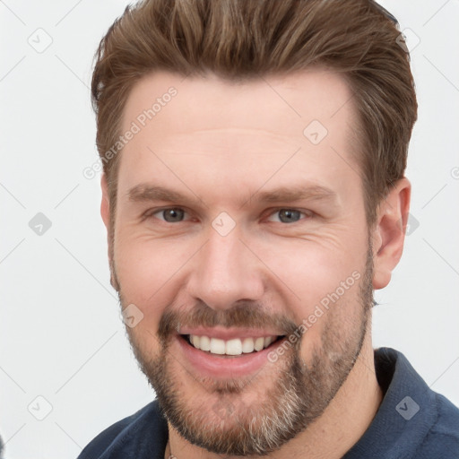 Joyful white adult male with short  brown hair and grey eyes