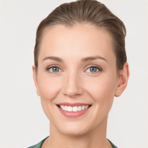 Joyful white young-adult female with short  brown hair and grey eyes