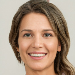 Joyful white young-adult female with long  brown hair and green eyes